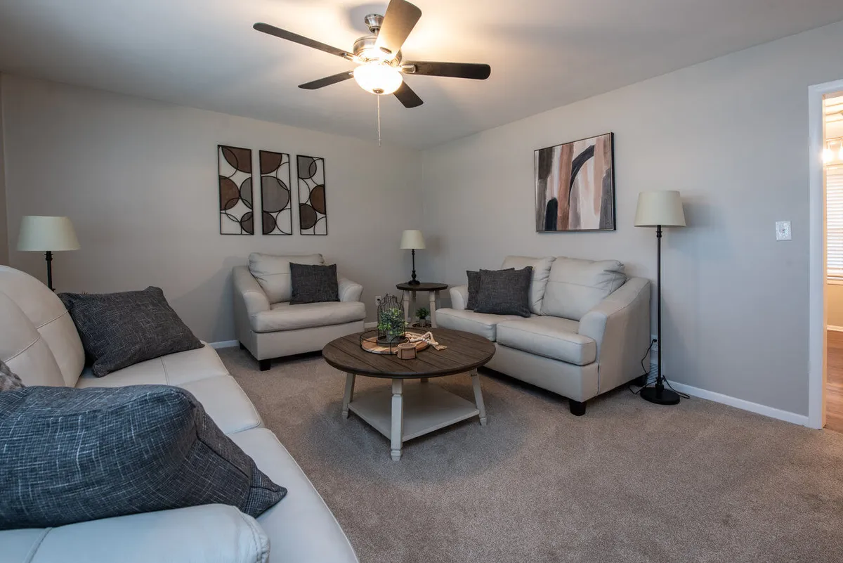 A comfortable living area with a leather sofa, coffee table, wall art, and warm lighting. The arrangement offers a welcoming environment for relaxing, socializing, or reflecting on the day's adventures in Kansas City.